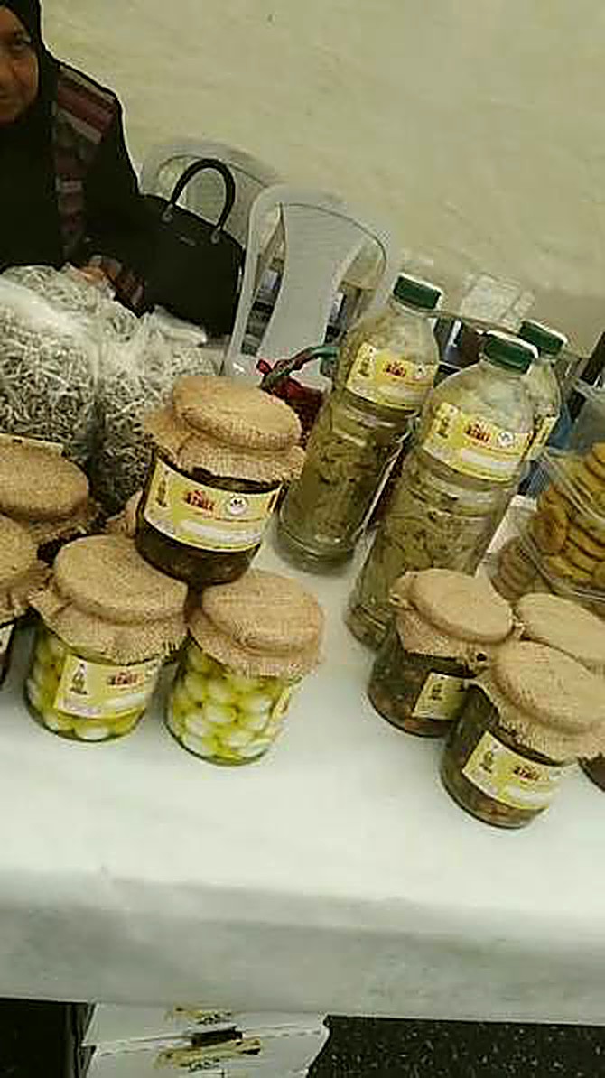 Jars of Mouneh Darna makdous and pickles with traditional burlap lids.